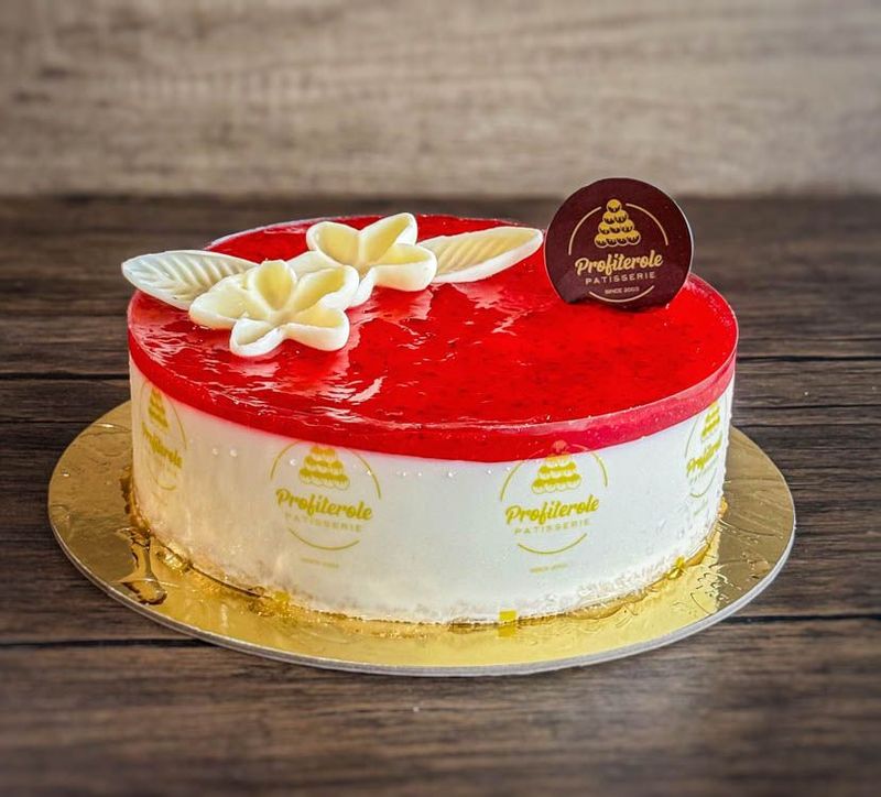 a strawberry cheesecake with strawberry jam and chocolate ganache on top