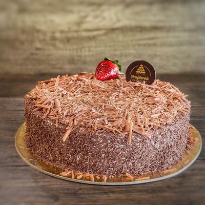 a black forest cake covered in chocolate sprinklers and chocolate finishing