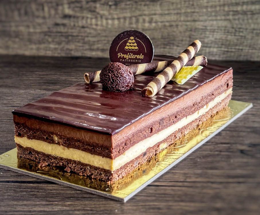 a log trio cake with a chocolate ball and wafers on top