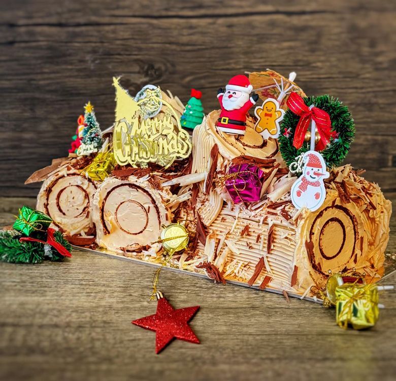 A close look on a Christmas Log Cake -  Belgium Chocolate, topping with various xmas figure decorations