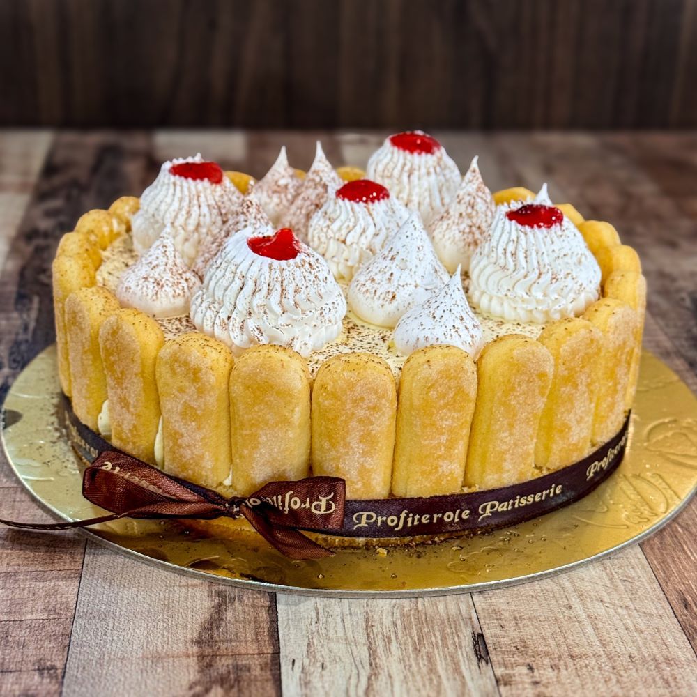 A fraisier cake with surrounded lady fingers side view