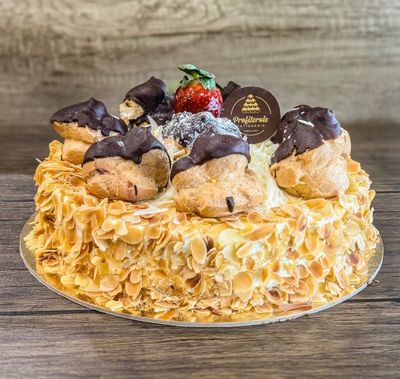 a white profiterole cake with 7 profiteroles on top