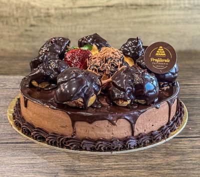 a mousse profiterole cake with 7 profiteroles on top
