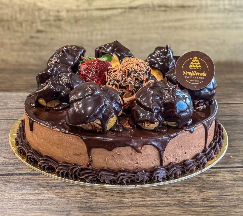 a mousse profiterole cake with 7 profiteroles on top