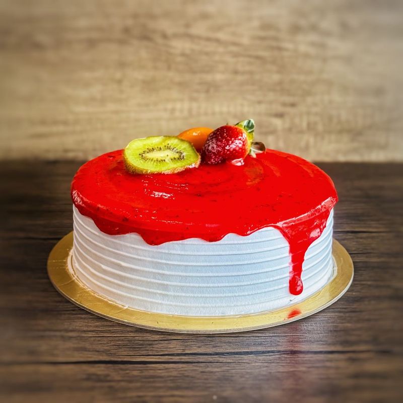 a round ice cream cake with strawberry sauce on top, decorated with a kiwi and strawberry.
