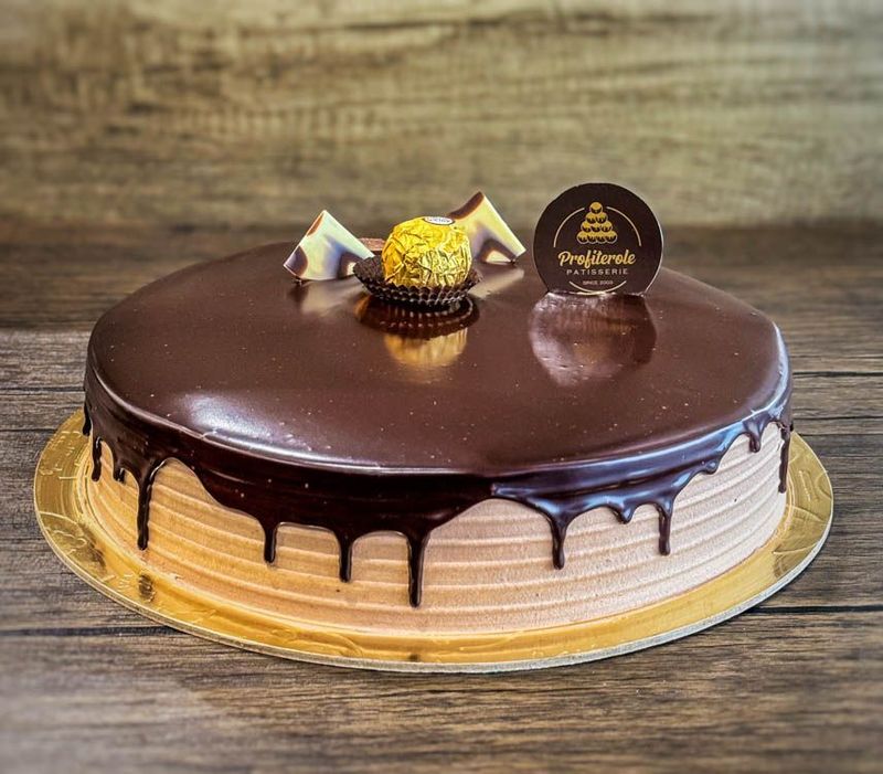 a ferrero cake with chocolate ganache and a fererro ball on top