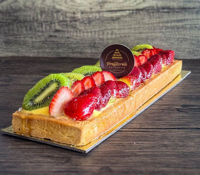 a log fruit cake with mixed fruits on top