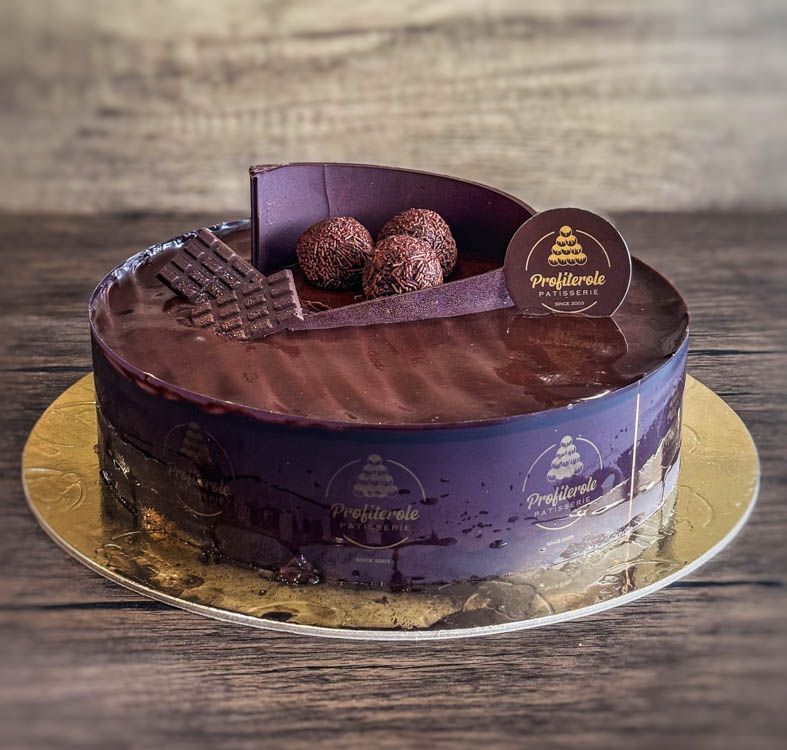 a chocolate mousse cake with chocolate balls and chocolate ganache on top