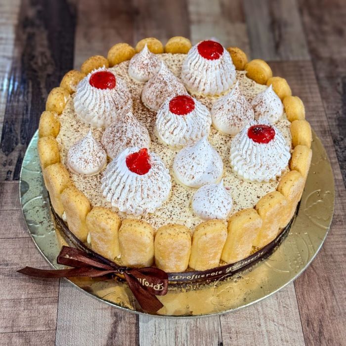 A fraisier cake with surrounded lady fingers side view