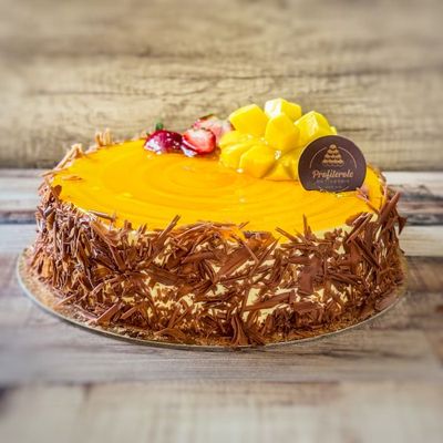 a close look on a mango cake with fresh strawberry and mango on top