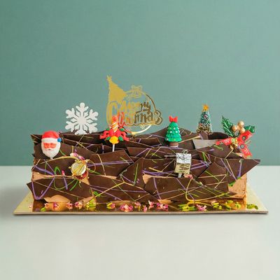 a dubai chocolate christmas log with christmas decorations 