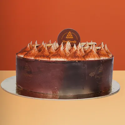 Tiramisu cake with dark chocolate sides and peaked cocoa-dusted mascarpone cream dollops on top by Profiterole Patisserie