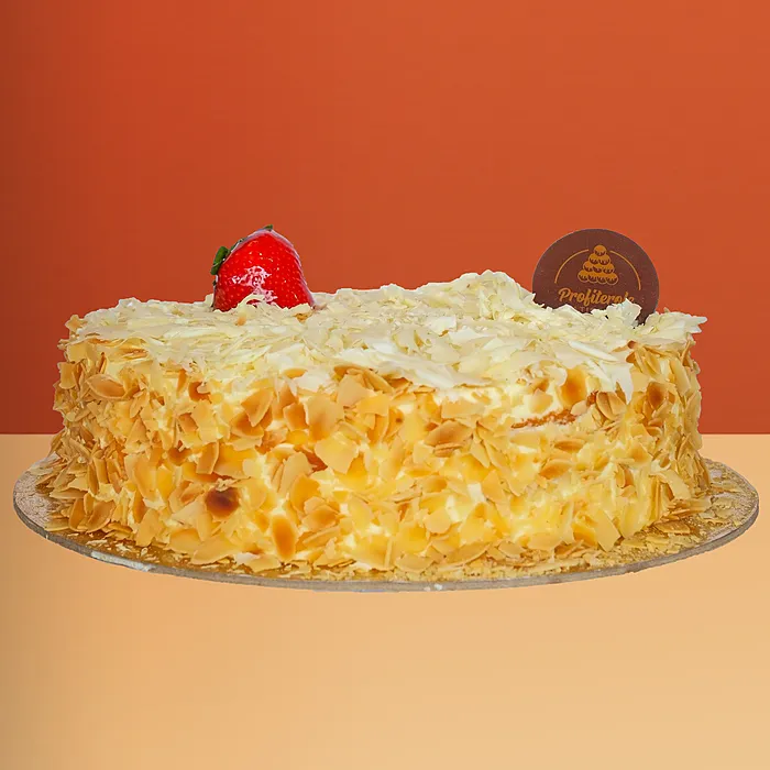 White forest cake with almond flakes, white chocolate shavings and a fresh strawberry by Profiterole Patisserie