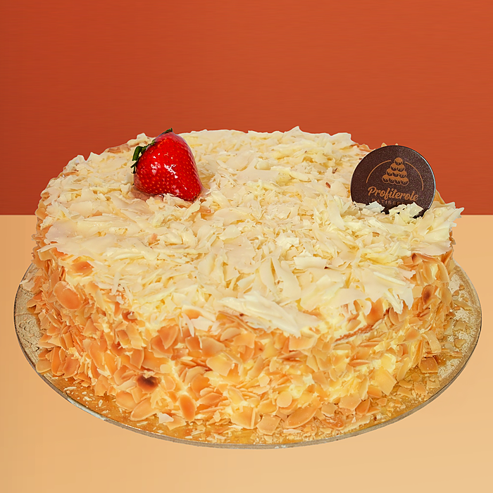 White forest cake with almond flakes, white chocolate shavings and a fresh strawberry by Profiterole Patisserie