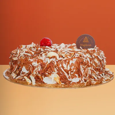 Double custard cake covered in dark and white chocolate shavings with a fresh strawberry on top by Profiterole Patisserie