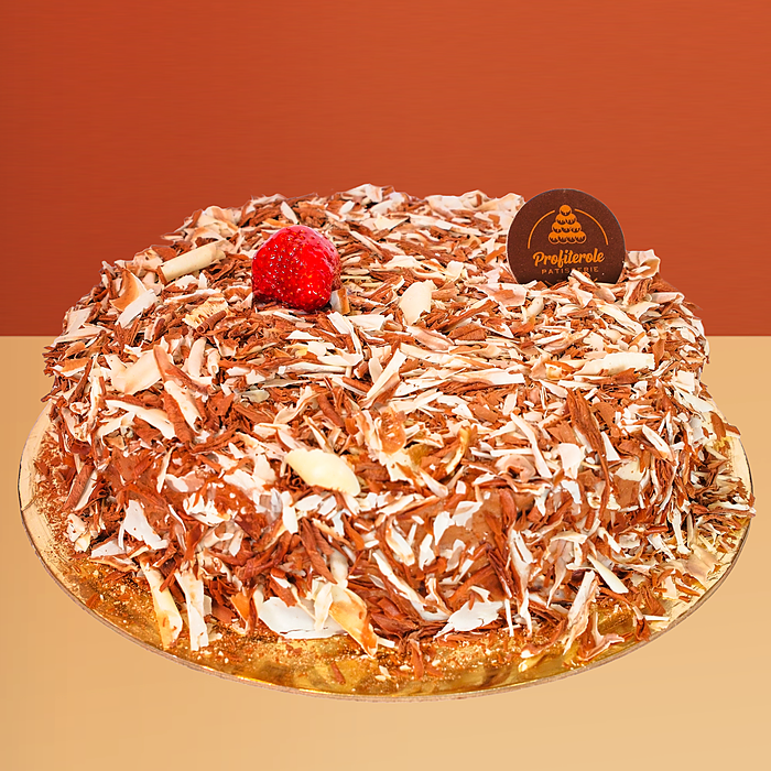 Double custard cake covered in dark and white chocolate shavings with a fresh strawberry on top by Profiterole Patisserie