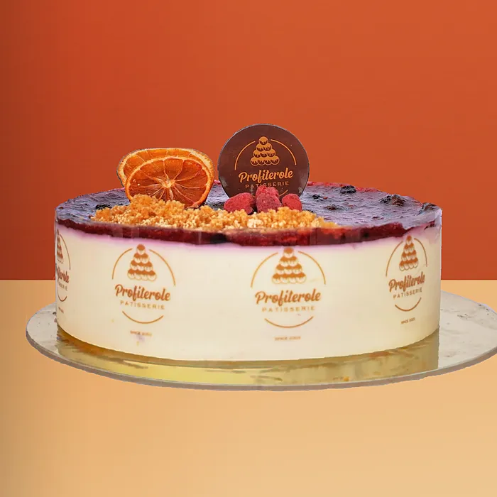 Blueberry Cheesecake Blueberry cheesecake with berry compote a dried orange slice fresh raspberries and crumble topping by Profiterole Patisserie