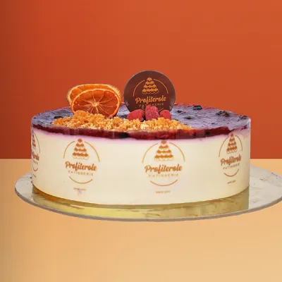 Blueberry cheesecake with berry compote a dried orange slice fresh raspberries and crumble topping by Profiterole Patisserie