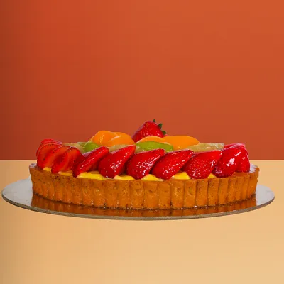 Fruit Cake - Round Round fresh fruit cake with glazed strawberries kiwi mango and banana slices arranged on a golden pastry base by Profiterole