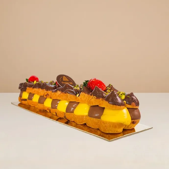 side view of the profiterole log cake showing the alternating arrangement of custard and chocolate-fille profiteroles