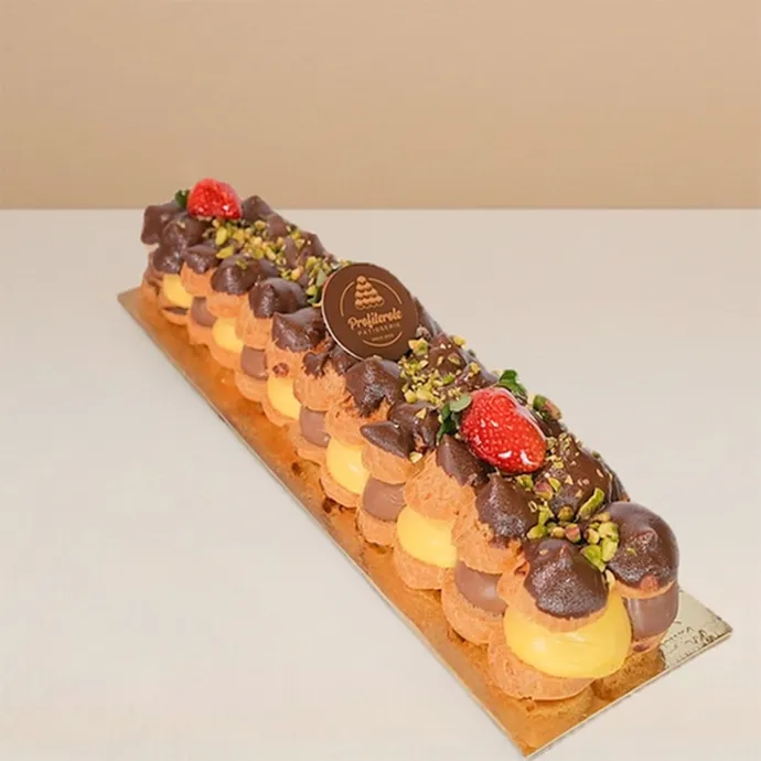 side view of the profiterole log cake showing the alternating arrangement of custard and chocolate-fille profiteroles