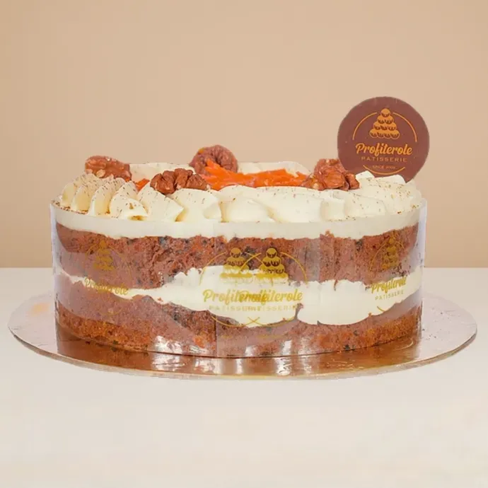 side view of carrot cake with cream cheese topping, walnuts and sultanas
