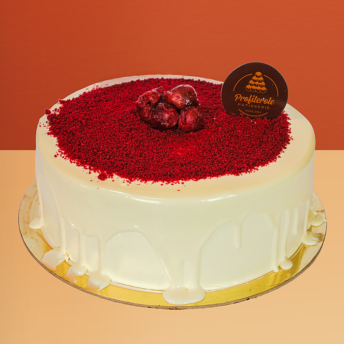 Red velvet cake with cream cheese frosting, white chocolate drip, crumbs & strawberries by Profiterole Patisserie