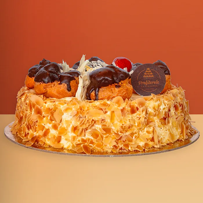 White profiterole cake with toasted almond sides and chocolate-dipped cream profiteroles by Profiterole Patisserie