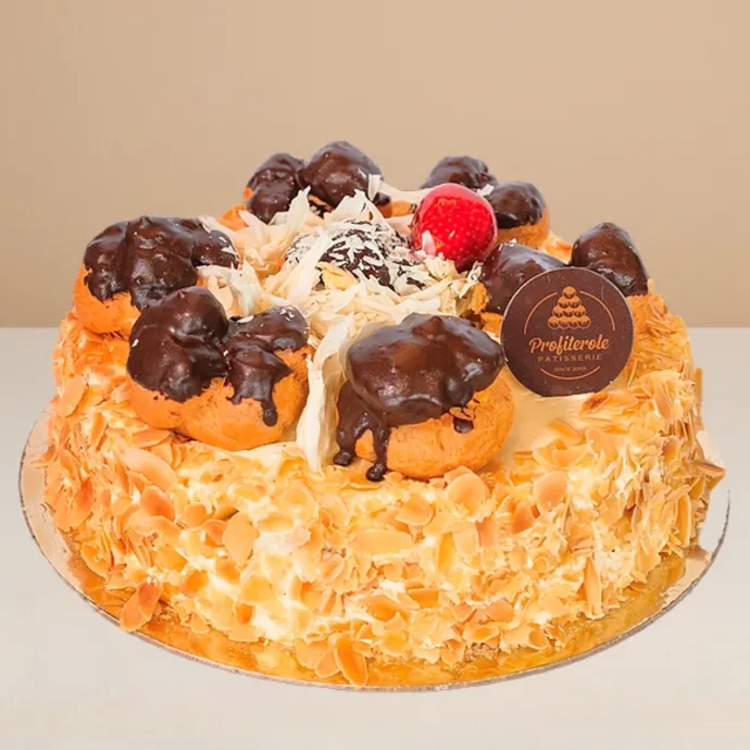 side view of the white profiterole cake showing the white forest cake base and profiteroles