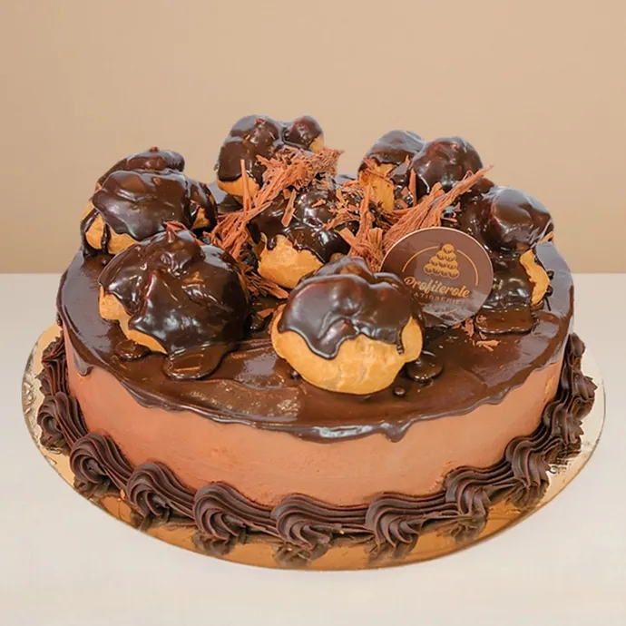 side view of the mousse profiterole cake showing the fine chocolate sponge base layer