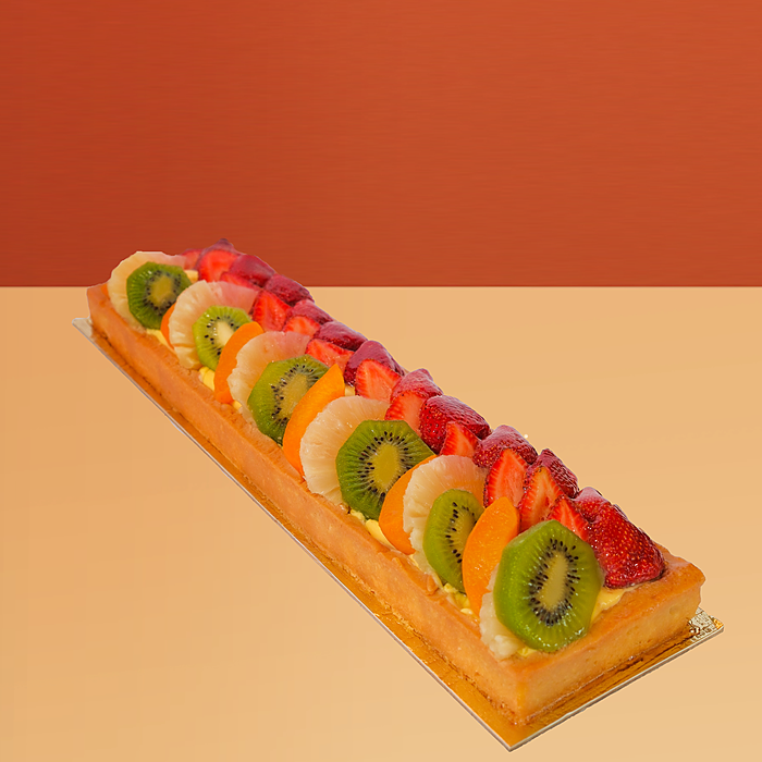 Log-shaped fresh fruit cake w/ rows of kiwi strawberry & mango on a golden pastry base by Profiterole Patisserie