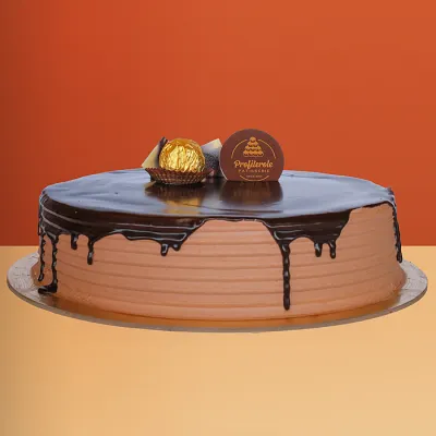 Ferrero Rocher cake with rich chocolate ganache drip and a golden Ferrero Rocher ball on top by Profiterole Patisserie