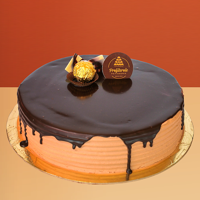 Ferrero Rocher cake with rich chocolate ganache drip and a golden Ferrero Rocher ball on top by Profiterole Patisserie