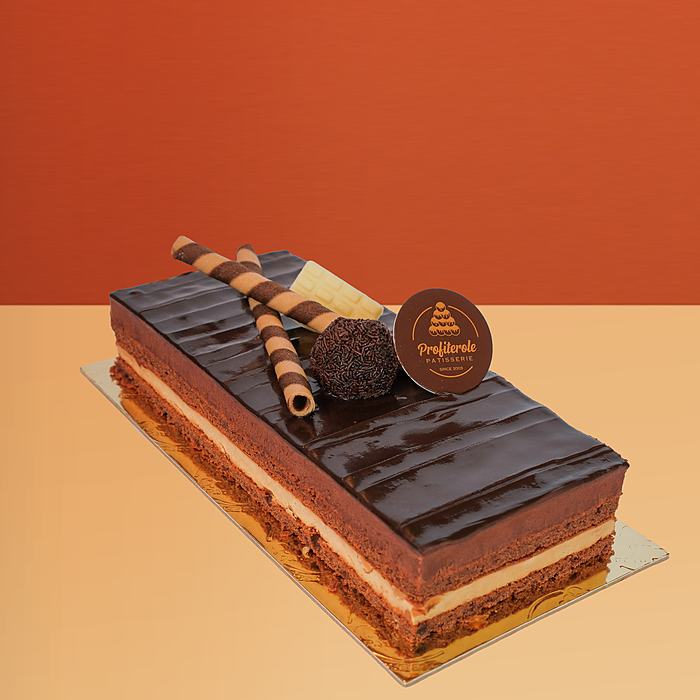 Rectangular trio log cake with chocolate & custard layers, glossy ganache and wafer rolls by Profiterole Patisserie