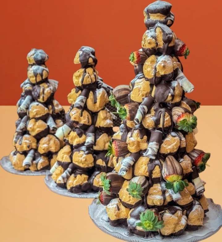 Croquembouche profiterole tower with dark chocolate, strawberries, and white chocolate curls
