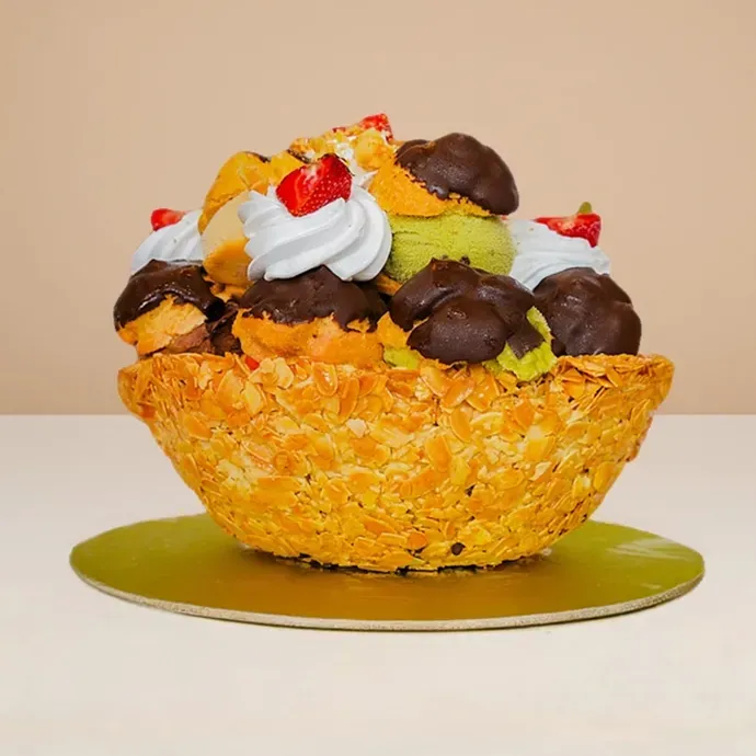 side view of the 17-piece profiterole ice cream cake showing the huge shortbread bowl of the 17 gelato-filled profiteroles