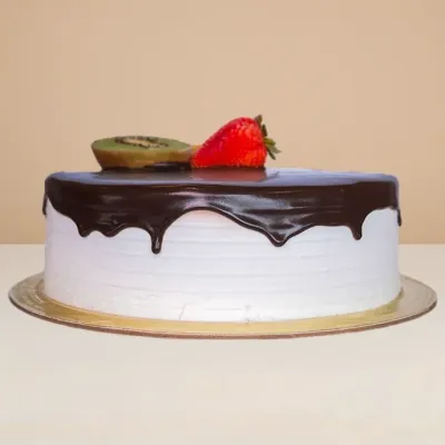 side view of the round ice cream cake showing the chocolate sauce dripping over its glossy side