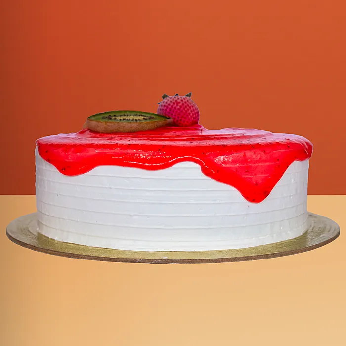 Round ice cream cake with pink strawberry sauce drip decorated w/ a kiwi slice and fresh strawberry by Profiterole Patisserie