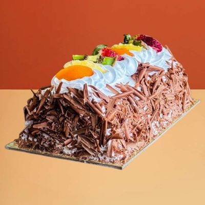 Chocolate ice cream cake log with chocolate shavings and fresh fruit