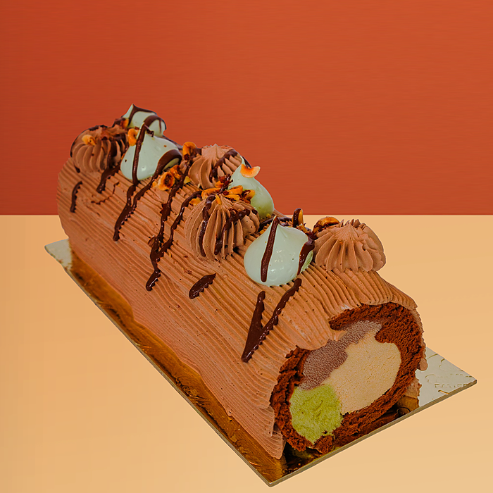 Chocolate Swiss roll ice cream cake with chocolate ganache piping showing hazelnut pistachio and chocolate gelato inside