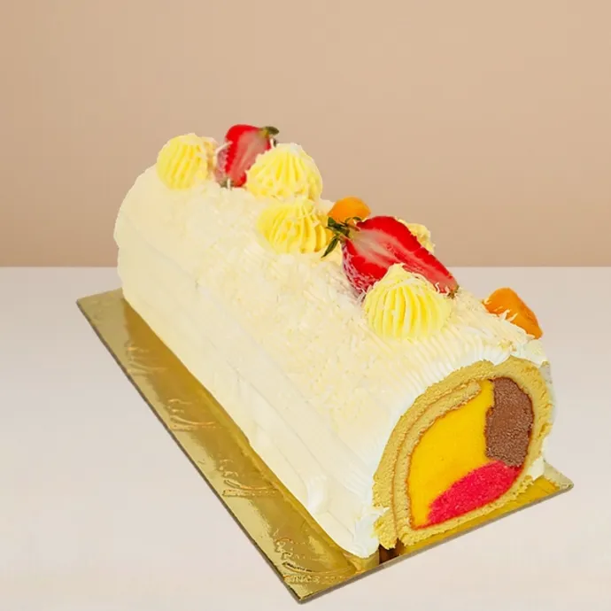 side view of the mango swiss roll ice cream cake, vanilla sponge wrapping the chocolate, strawberry, and mango ice cream