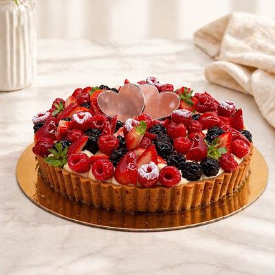 Mixed berries tart with a golden shortbread base, filled with creamy custard and topped with fresh strawberries, raspberries.