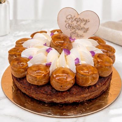 St Honoré cake with a layered mille-feuille base, filled with custard and topped with caramel-glazed profiteroles 