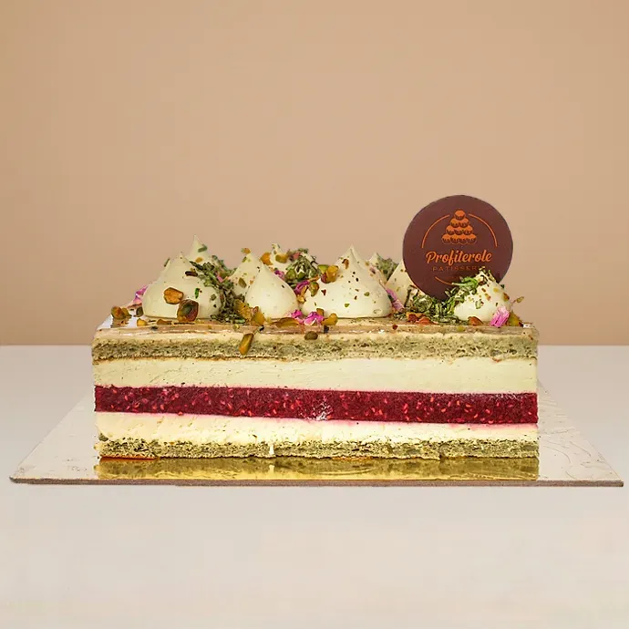 side view of the pistachio raspberry bliss cake showing the clean details of its cream, vanilla, and pistachio coulis layers