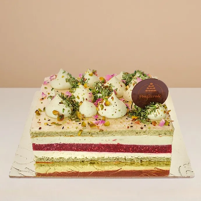 side view of the pistachio raspberry bliss cake showing the clean details of its cream, vanilla, and pistachio coulis layers