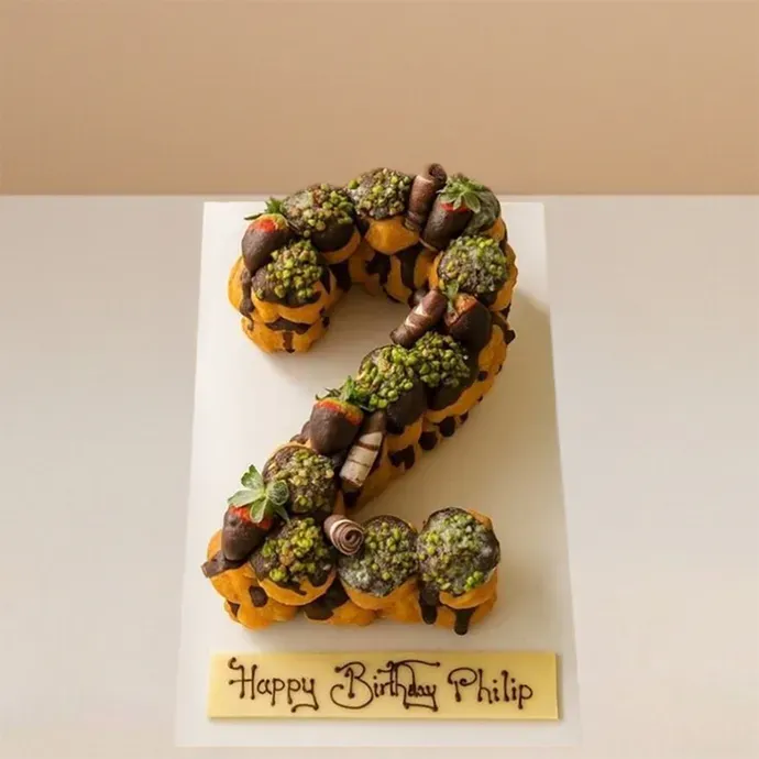 number cake made with profiteroles stacked and arranged together to form the number "2"