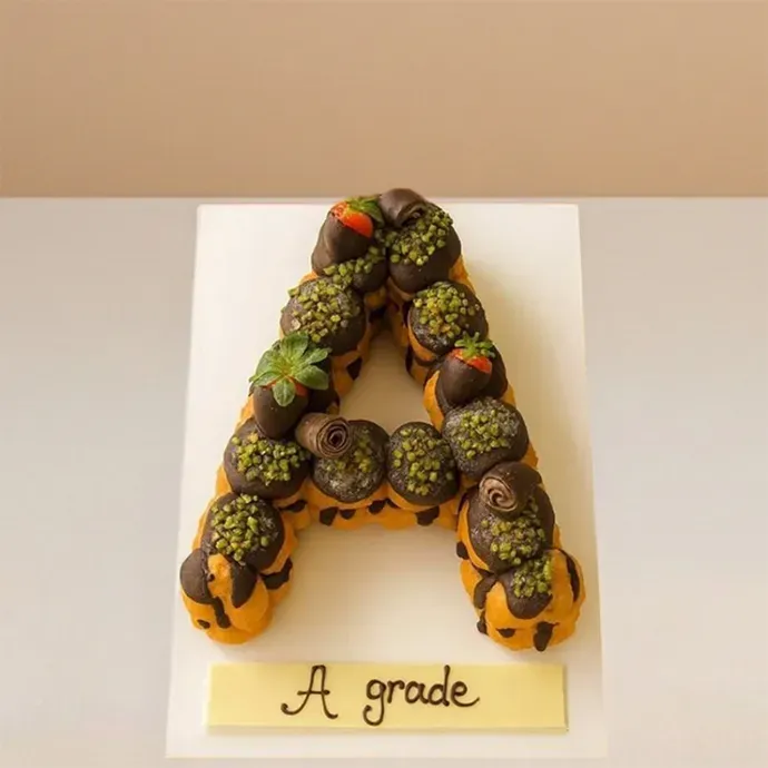 single letter cake made with profiteroles stacked together to form the letter "A"