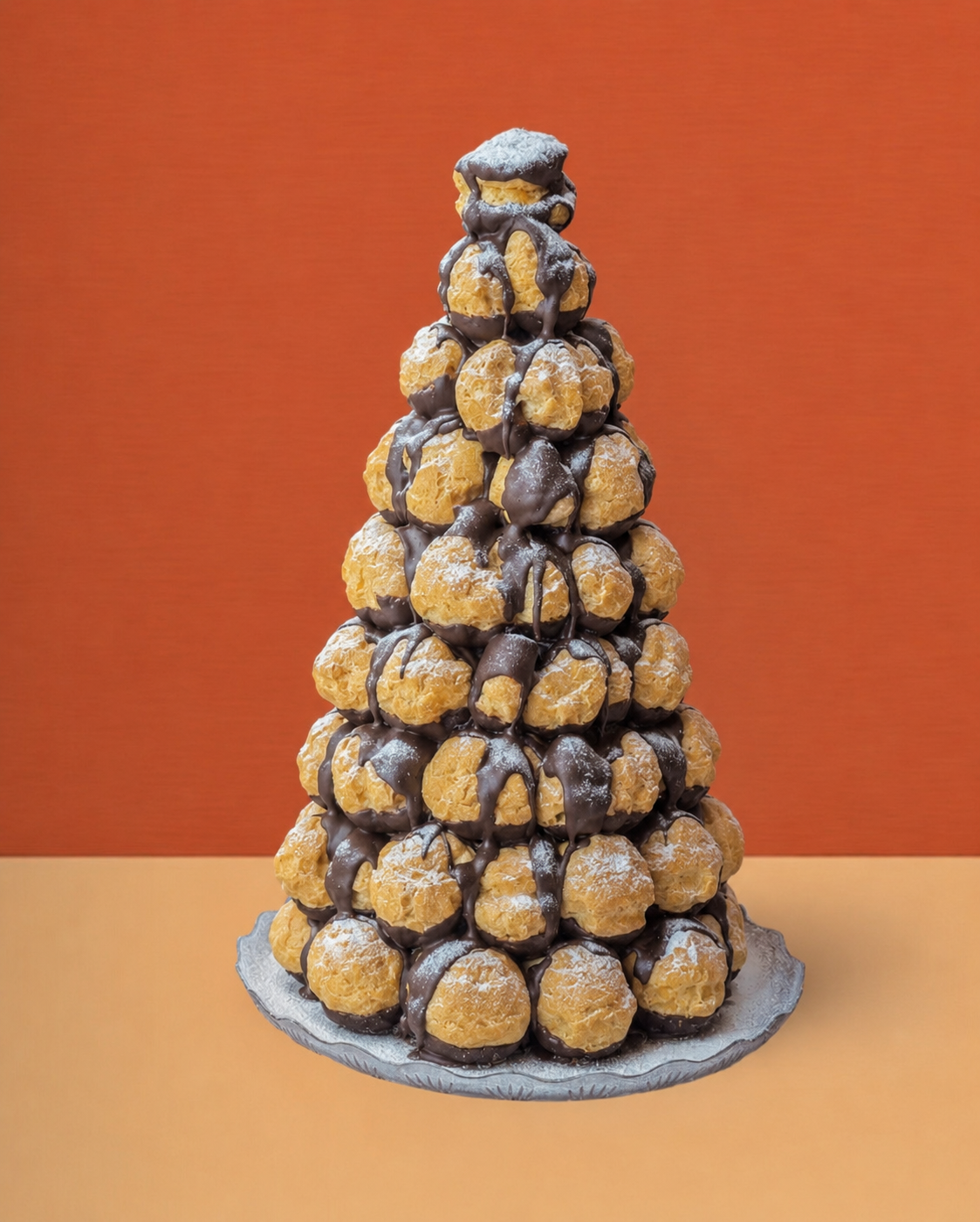 a profiterole tower decorated with chocolate-dipped strawberries