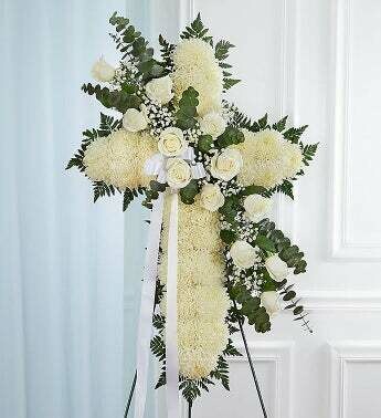 Croix funéraire jetté de fleurs blanche