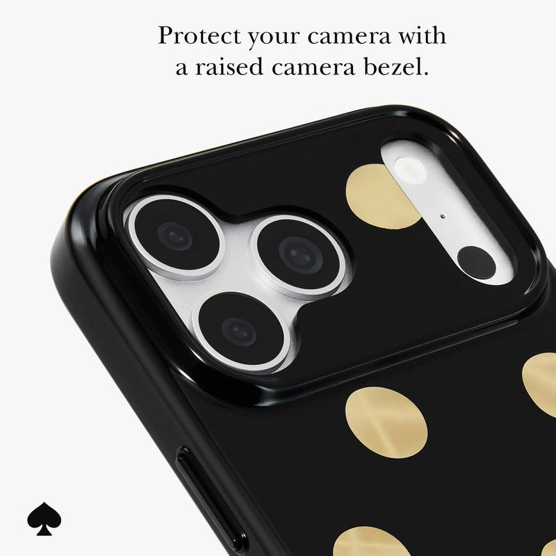 A close-up of a black phone case with gold polka dots and a raised camera bezel, shown on a light g…